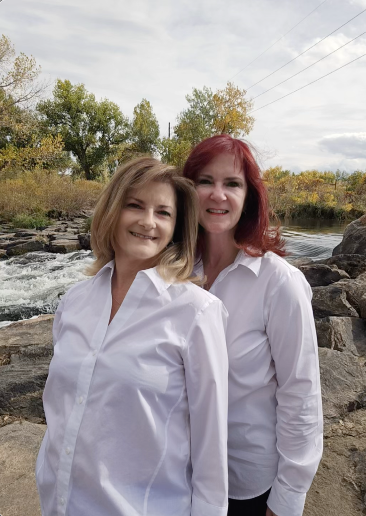 A picture of twin sisters, holistic nurses, standing outside by a river